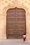 Baeza_039_05302015 - Tahia dwarfed by a large door belonging to the Palacio Jabalquinto