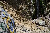 Bonita_Falls_143_06122020 - Looking down past a tagged boulder with lots of people down below at the base of Bonita Falls' plunge pool
