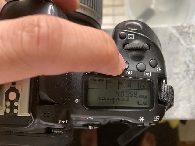 Pressing the ISO button on my DSLR camera to get into the ISO settings mode...