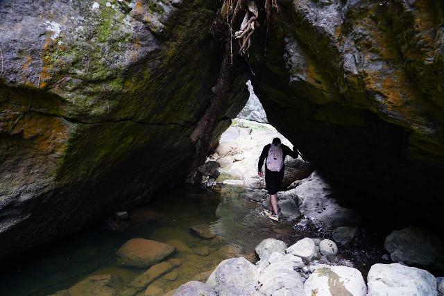 Canon_de_San_Cristobal_107_04202022 - Ricardo navigating through an 'arch' beneath a bunch of fallen boulders in the narrowest part of Cañon de San Cristóbal