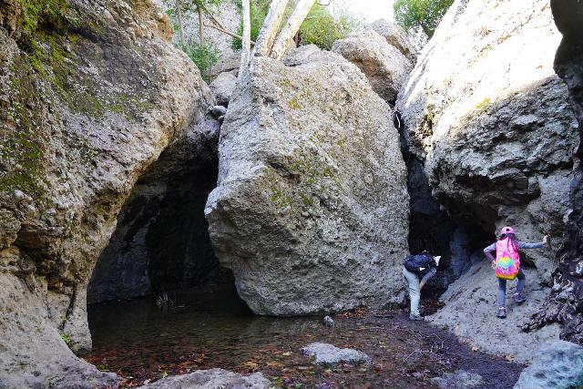 Circle_X_Ranch_Grotto_220_01302021 - Julie and Tahia looking behind the giant boulder concealing the lower part of the Grotto Falls under drier conditions in early 2021
