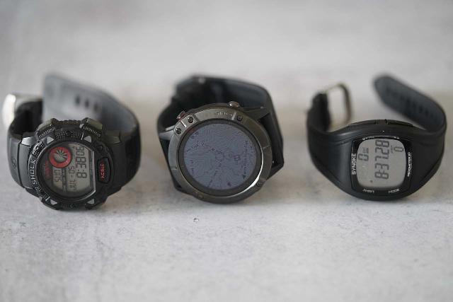 The Garmin Fenix 6X Pro Sapphire watch (in the middle) compared to my standard watch (left) and a very basic fitness watch (right)