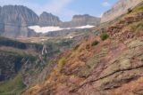 Grinnell_Glacier_190_08072017 - Context of the Grinnell Glacier Trail hikers on it providing scale of the dropoffs and the Grinnell Falls in the distance