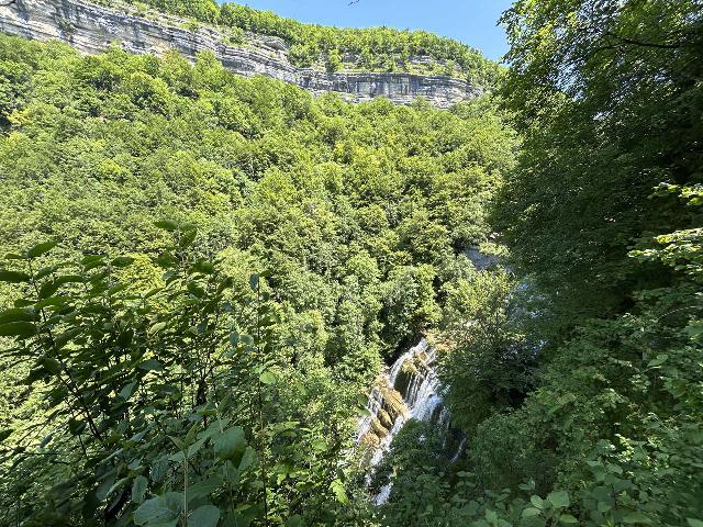 Herisson_065_iPhone_14_06172025 - Partial overlook of l'Eventail backed by tall cliffs as seen from an easy-to-miss lookout on the south side of the river just downstream of the Passarelle Sarrazine footbridge