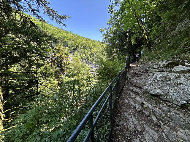 Herisson_141_iPhone_14_06172025 - A narrow ledge trail with railings on the way up to the brink of the Grand Saut