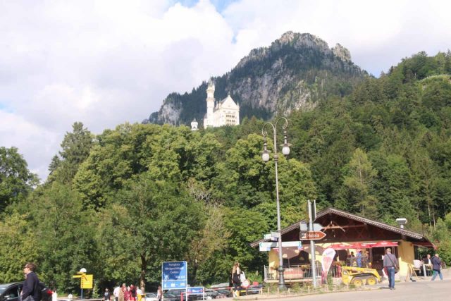 Ludwigs_Castles_563_06252018 - Neuschwanstein Castle looms high over the car park areas at the foot of the hills and mountains
