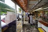 Mogami_Shiraito_Falls_050_07082023 - Looking back along an aisle with food stalls or counters at the Mogami Shiraito Falls drive-in