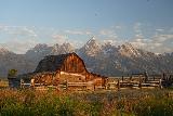 Mormon_Row_051_08072020 - Orangish glow of the Moulton Barn fronting the Grand Tetons in the background