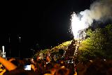 Noboribetsu_225_07132023 - More contextual look over some peoples' heads towards the firework-torch-wielding evening performer at Jigokudani