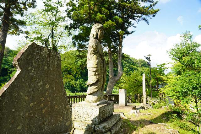 Otsujigataki_019_07212023 - A stone statue flanked by some stone tablets with inscriptions on them at Otsujigataki Falls