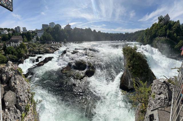 Rhine_Falls_168_iPhone_14_06272025 - Looking upstream at part of the Rhine Falls towards the railway and pedestrian bridge as seen from the lookout at the top of the Rock Island
