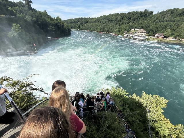 Rhine_Falls_175_iPhone_14_06272025 - Looking down at a line of people waiting their turn to go up (as well as back down!) the rock for 360 degree views from the heart of the Rhine Falls