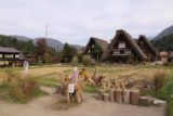 Shirakawa_095_10202016 - Looking past some scarecrows towards a field with some interesting-looking traditional homes at Ogimachi
