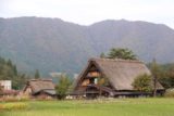 Shirakawa_104_10202016 - Looking across a field towards some more thatched-roof homes of Ogimachi backed by beautiful mountains