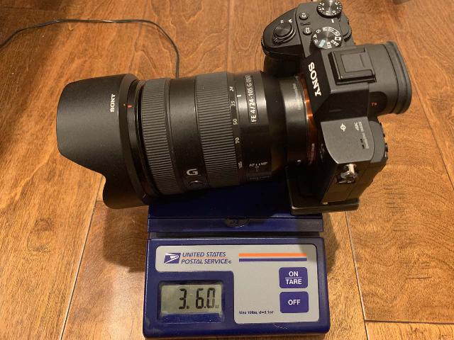 The Sony SEL24105G FE 24-105mm f/4 OSS G Lens sitting on a postal scale