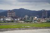 Taipei_262_06272023 - Looking over what looked to be a local airport towards the ferry wheel and some other large buildings nearby it after having gotten on a train after our lunch at Chun Shui Tang