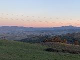 Vignoni_036_iPhone_11182023 - Looking towards rolling Tuscan hills underneath some post sunset orangish skies as we got close to Bagno Vignoni