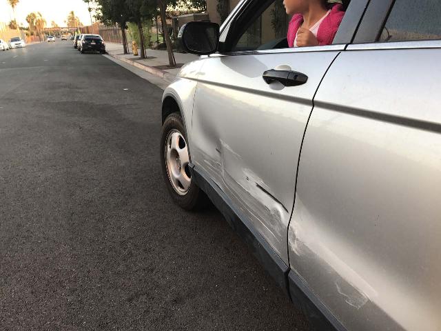 Looking at the damage done to our car when we were about to turn left into a parking lot